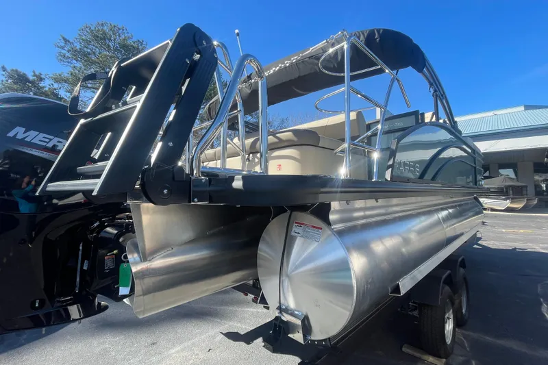 Slide: The Image of 2026 Harris Cruiser 210 pontoon boat with ladder and Mercury engine, parked outdoors. - 3