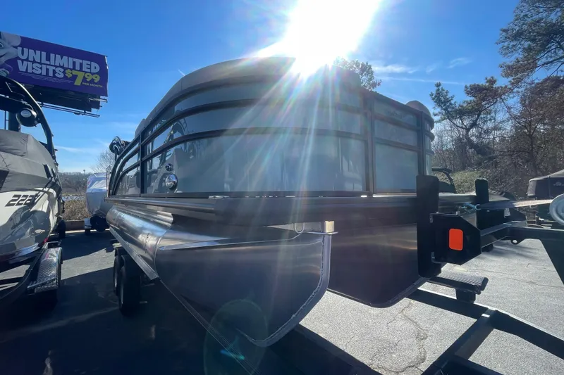 Slide: The Image of 2026 Harris Cruiser 210 pontoon boat on trailer under bright sunlight. - 5