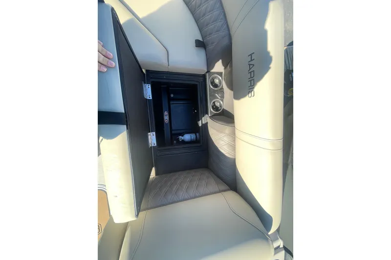Slide: The Image of 2026 Harris Cruiser 210 boat interior with open storage compartment and cup holders. - 7