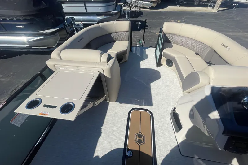 Slide: The Image of Interior of 2026 Harris Cruiser 210 pontoon boat with beige seating and table. - 8