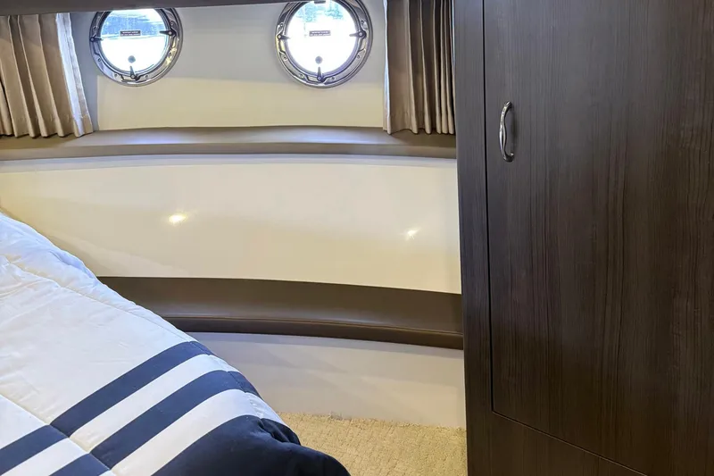 Slide: The Image of Interior of 2013 Carver C34 yacht with portholes and wooden cabinetry. - 17