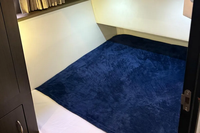 Slide: The Image of Interior cabin of 2013 Carver C34 yacht with blue bedding and wooden cabinetry. - 18