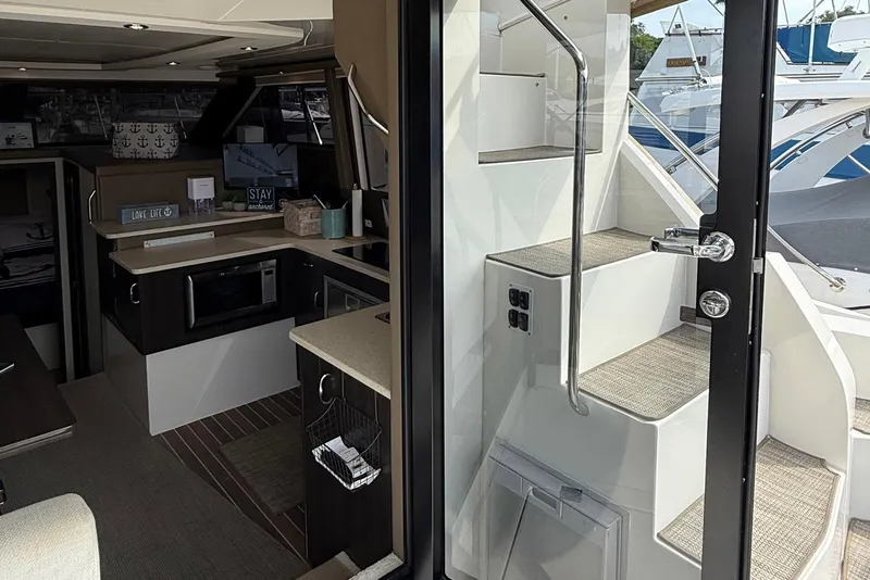 Slide: The Image of Interior view of 2013 Carver C34 yacht, featuring modern kitchen and staircase. - 29