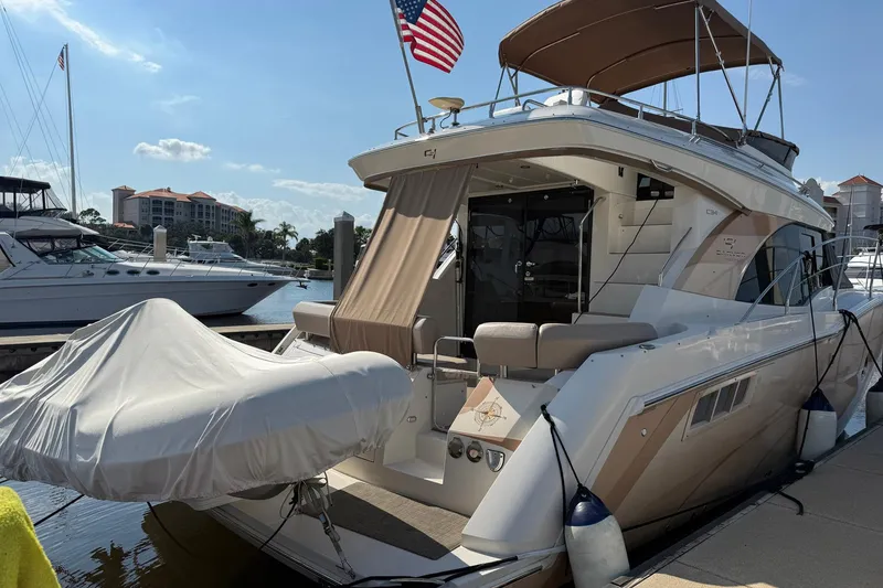 Slide: The Image of 2013 Carver C34 yacht docked, featuring covered tender and American flag. - 31