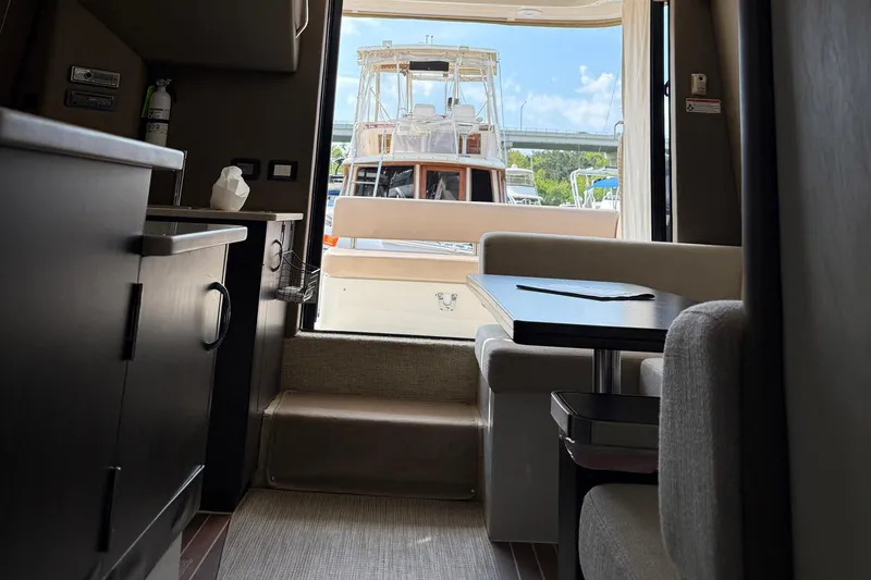 Slide: The Image of Interior of 2013 Carver C34 yacht with dining area and view of docked boat. - 12