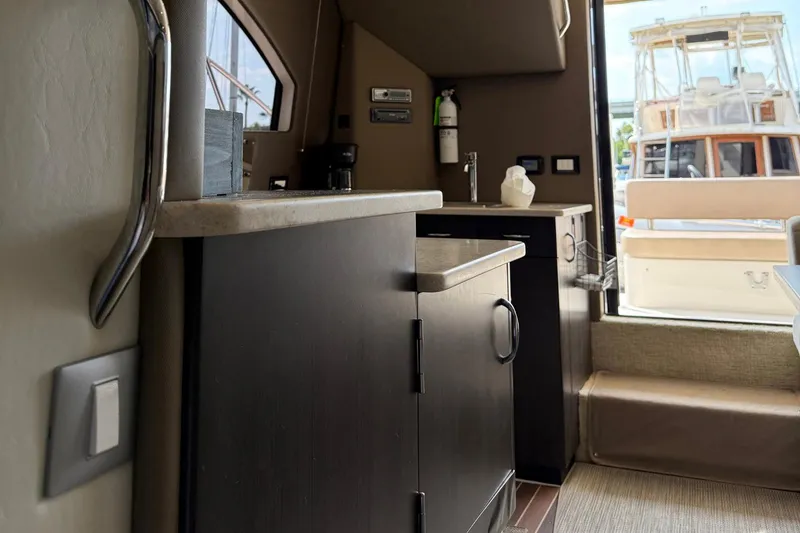 Slide: The Image of Interior of a 2013 Carver C34 yacht, featuring a compact kitchen area. - 14