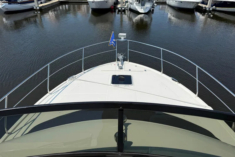 Slide: The Image of 2013 Carver C34 yacht bow view in marina, surrounded by water and docked boats. - 22