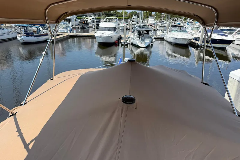 Slide: The Image of Covered deck of 2013 Carver C34 yacht in marina, surrounded by boats. - 28
