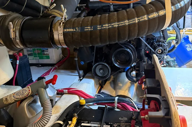 Slide: The Image of Engine compartment of a 2013 Carver C34 boat, featuring hoses and battery connections. - 33
