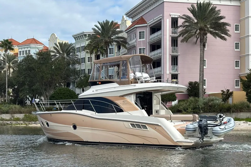 Slide: The Image of 2013 Carver C34 yacht cruising near colorful waterfront buildings and palm trees. - 4