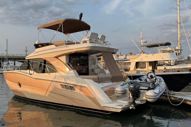 Slide: The Image of 2013 Carver C34 yacht docked with inflatable boat attached, under a cloudy sky. - 40