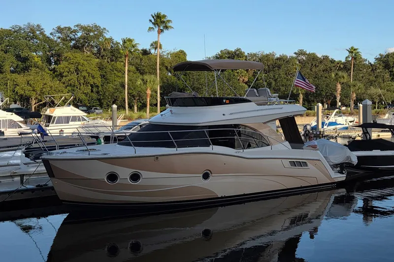 Slide: The Image of 2013 Carver C34 yacht docked at marina, surrounded by trees and other boats. - 41