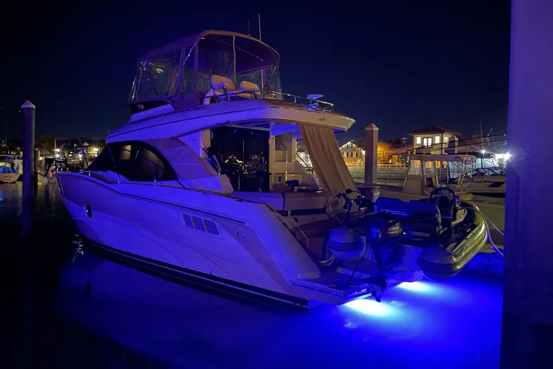Slide: The Image of 2013 Carver C34 yacht docked at night with blue underwater lights. - 42