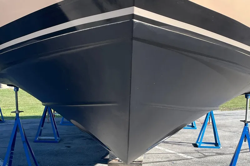 Slide: The Image of 2013 Carver C34 boat hull on stands, showcasing sleek design and craftsmanship. - 44