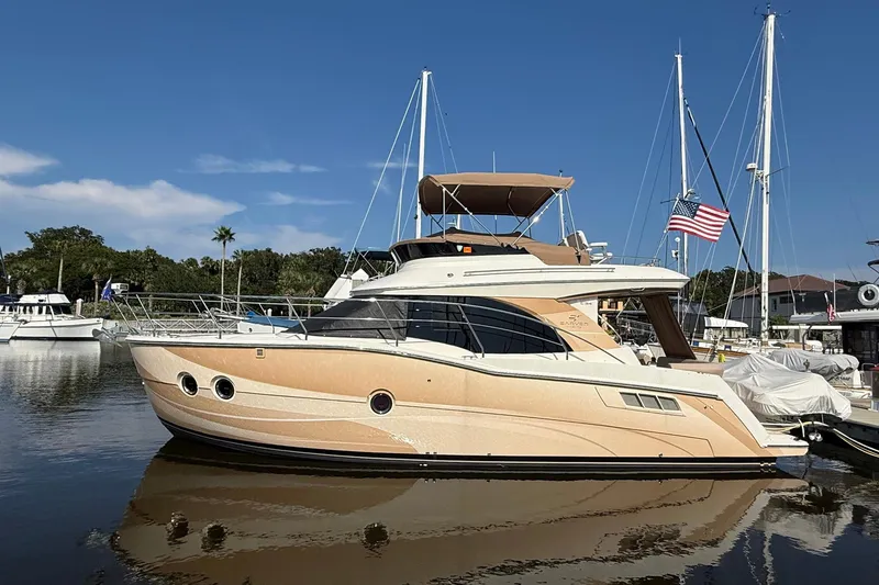 Slide: The Image of 2013 Carver C34 yacht docked in a marina, featuring sleek design and American flag. - 5