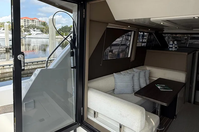 Slide: The Image of 2013 Carver C34 yacht interior with cozy seating and marina view. - 8