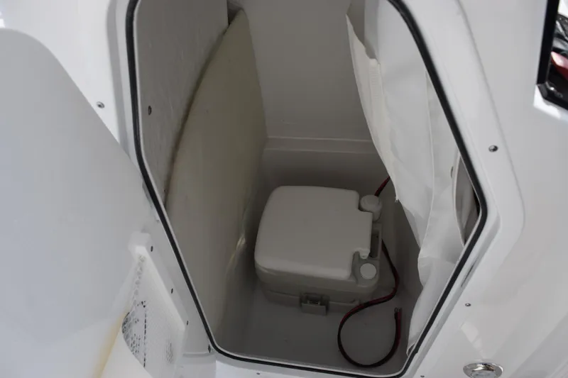 Slide: The Image of 2026 Sea Hunt Ultra 219 boat interior with compact marine toilet. - 11