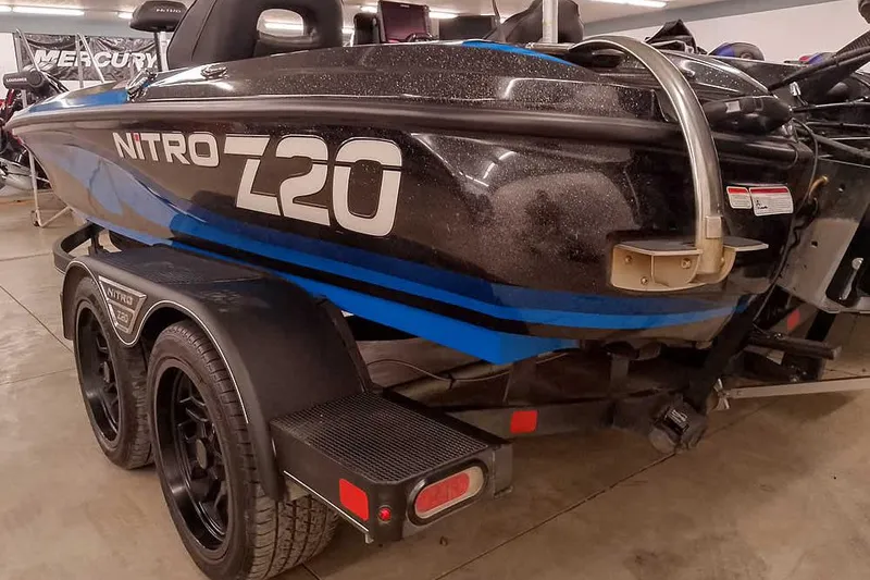 Slide: The Image of 2022 Nitro Z20 boat on trailer, black and blue design, in showroom. - 11