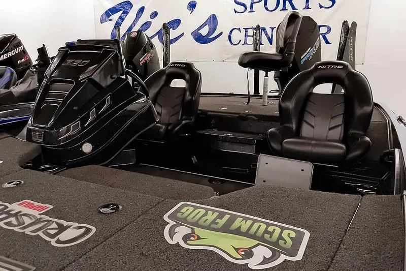 Slide: The Image of 2022 Nitro Z20 boat interior with black seats and engine, displayed at sports center. - 9