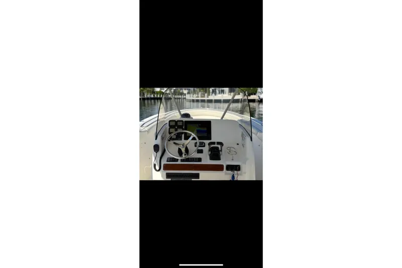Slide: The Image of 2009 Pursuit S 310 Sport boat bow with cushioned seating and wooden table. - 10