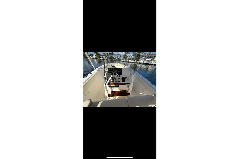 Slide: The Image of 2009 Pursuit S 310 Sport boat bow with cushioned seating on calm water. - 11
