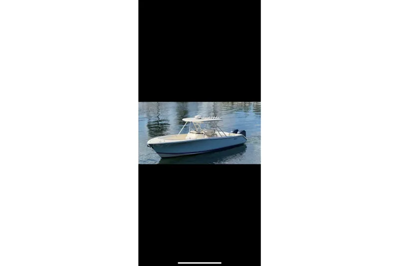 Slide: The Image of 2009 Pursuit S 310 Sport boat on calm water, featuring Garmin equipment. - 2