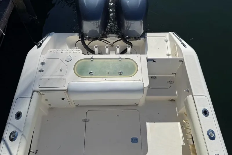 Slide: The Image of 2009 Pursuit S 310 Sport boat deck with dual engines and storage compartments. - 21