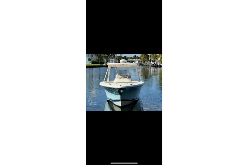 Slide: The Image of 2009 Pursuit S 310 Sport boat on calm water, featuring twin engines. - 4