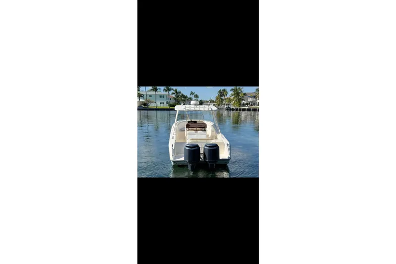 Slide: The Image of 2009 Pursuit S 310 Sport boat docked on calm water, rear view. - 7