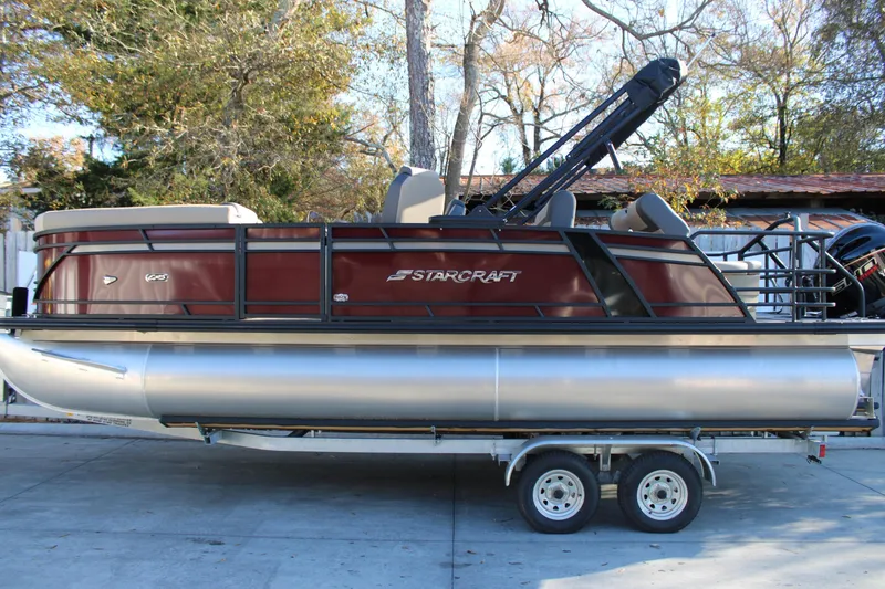 The Image of 2026 Starcraft EXS 3 DL pontoon boat on trailer, parked outdoors. - 1