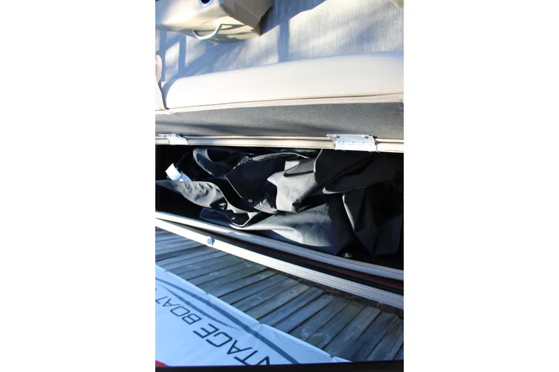 Slide: The Image of 2026 Starcraft EXS 3 DL boat storage compartment with black cover inside. - 14