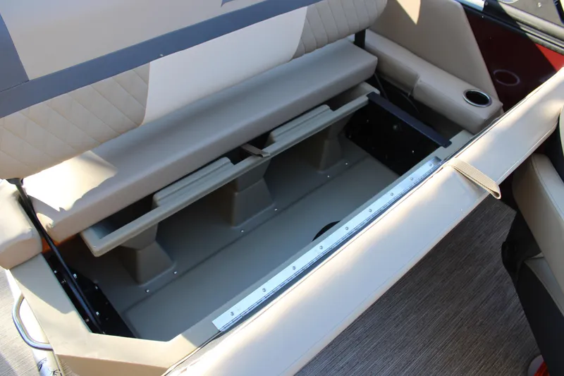 Slide: The Image of 2026 Starcraft EXS 3 DL boat interior storage compartment with beige seating and cup holder. - 19