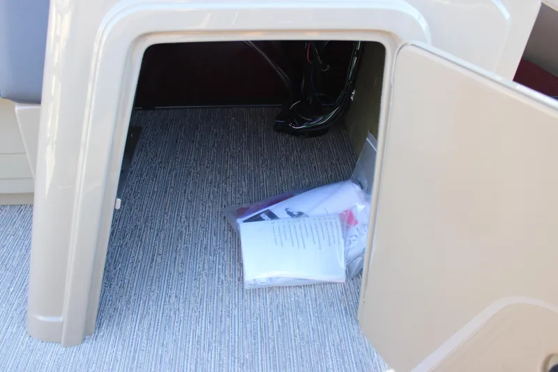 Slide: The Image of Open storage compartment in 2026 Starcraft EXS 3 DL boat with documents inside. - 29