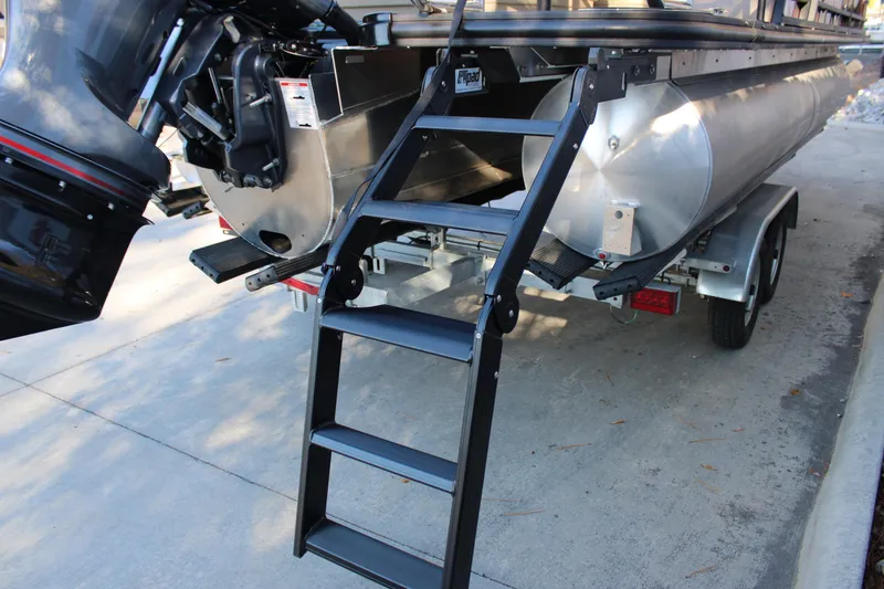 Slide: The Image of 2026 Starcraft EXS 3 DL pontoon boat with ladder and trailer, rear view. - 7