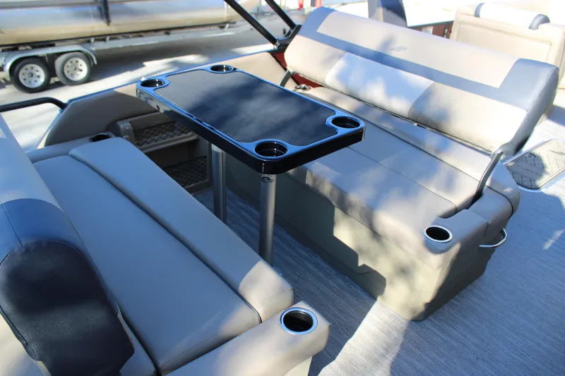 Slide: The Image of 2026 Starcraft EXS 3 DL boat interior with seating and table featuring cup holders. - 9