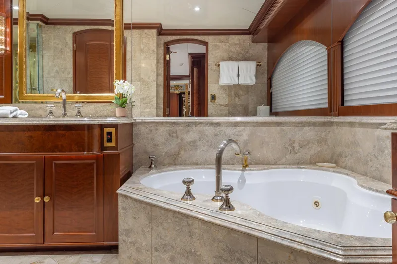 Slide: The Image of Luxurious yacht bathroom with marble finishes, elegant wood cabinetry, and a spacious bathtub. - 11