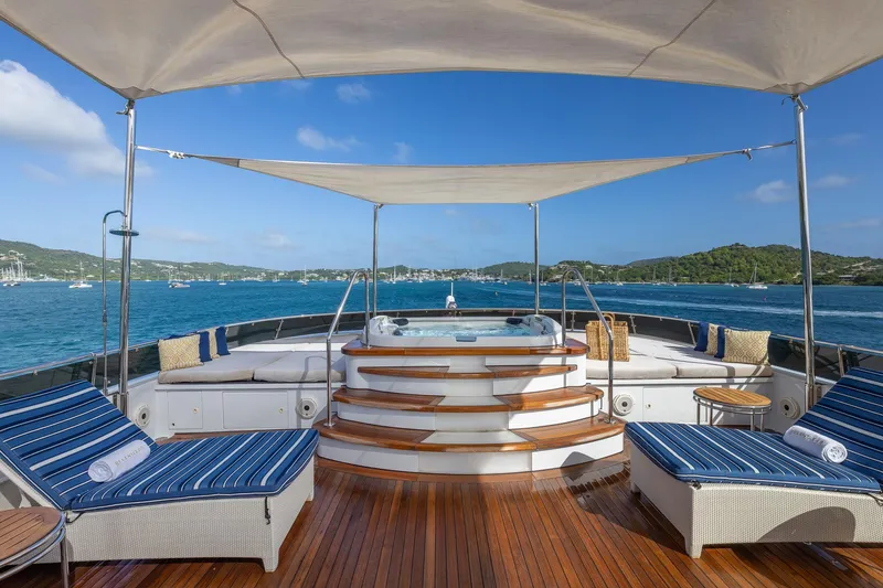 Slide: The Image of Luxurious 2001 TRINITY Tri-Deck MY yacht deck with sun loungers and hot tub, overlooking serene waters. - 34