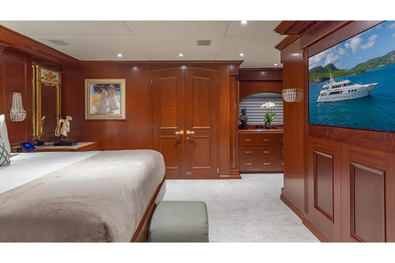 Slide: The Image of Luxurious yacht bedroom with elegant wood paneling, artwork, and a large screen displaying a yacht. - 8