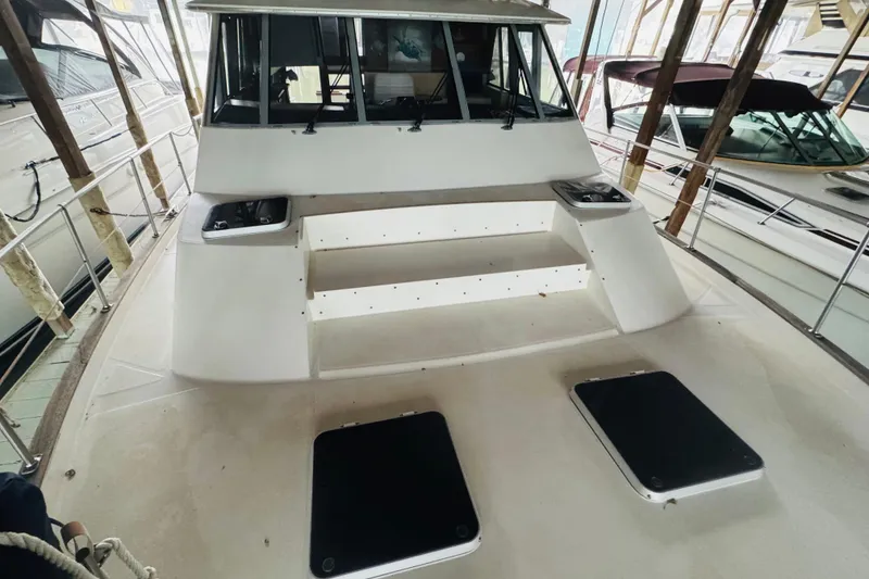 Slide: The Image of 1987 Bayliner 4550 Motoryacht deck view with steps and hatches in a marina. - 13