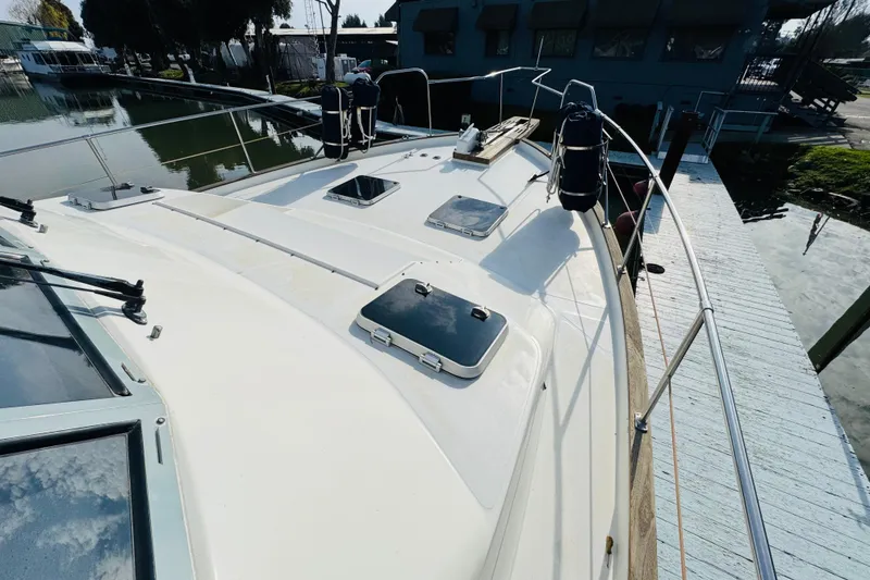 Slide: The Image of 1987 Bayliner 4550 Motoryacht deck view, docked near a calm waterfront. - 18
