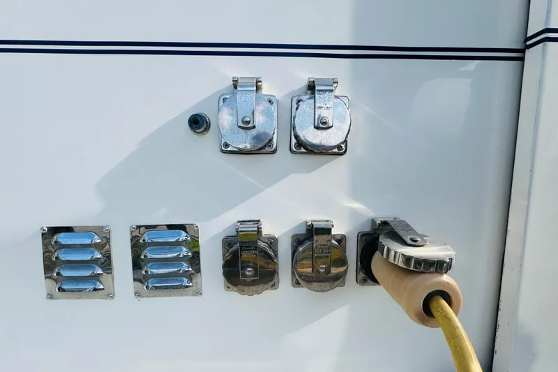 Slide: The Image of 1987 Bayliner 4550 Motoryacht power connections and vents on white exterior. - 21