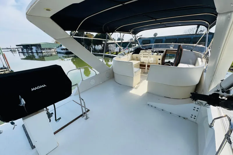 Slide: The Image of 1987 Bayliner 4550 Motoryacht with spacious deck and seating, docked by calm waters. - 25