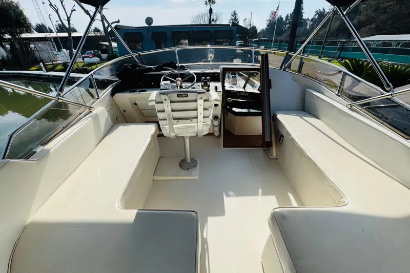 Slide: The Image of 1987 Bayliner 4550 Motoryacht cockpit with seating, steering wheel, and open cabin door. - 26