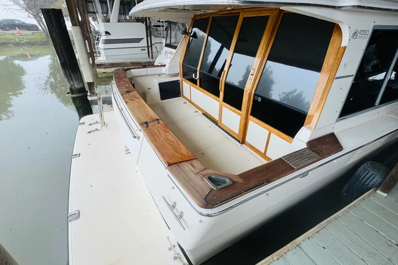 Slide: The Image of 1987 Bayliner 4550 Motoryacht docked, featuring wooden accents and spacious deck area. - 30