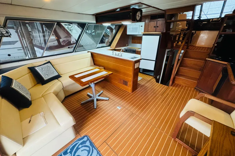 Slide: The Image of 1987 Bayliner 4550 Motoryacht interior with wood flooring, kitchenette, and seating area. - 36