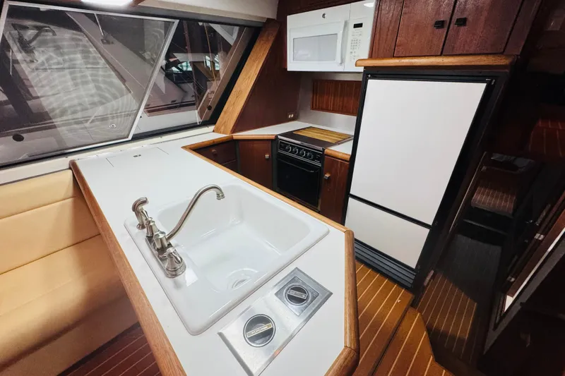 Slide: The Image of 1987 Bayliner 4550 Motoryacht kitchen with sink, stove, and refrigerator. - 47
