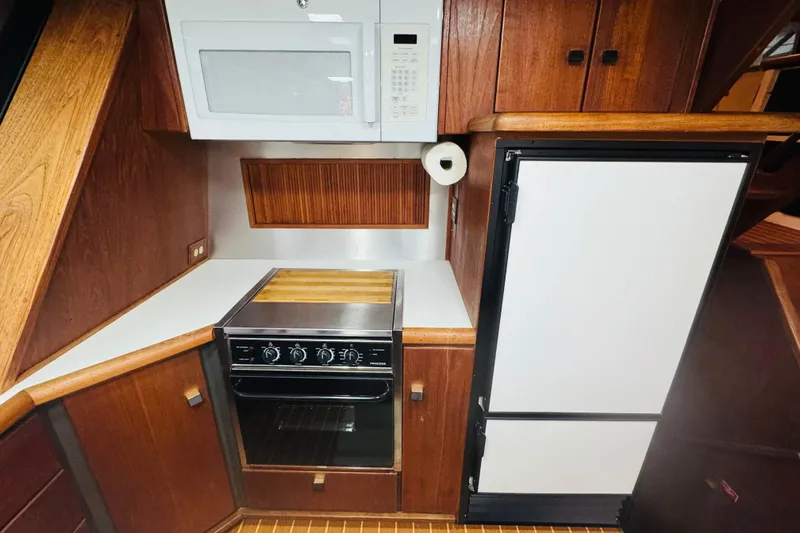 Slide: The Image of 1987 Bayliner 4550 Motoryacht kitchen with stove, microwave, and refrigerator. - 48