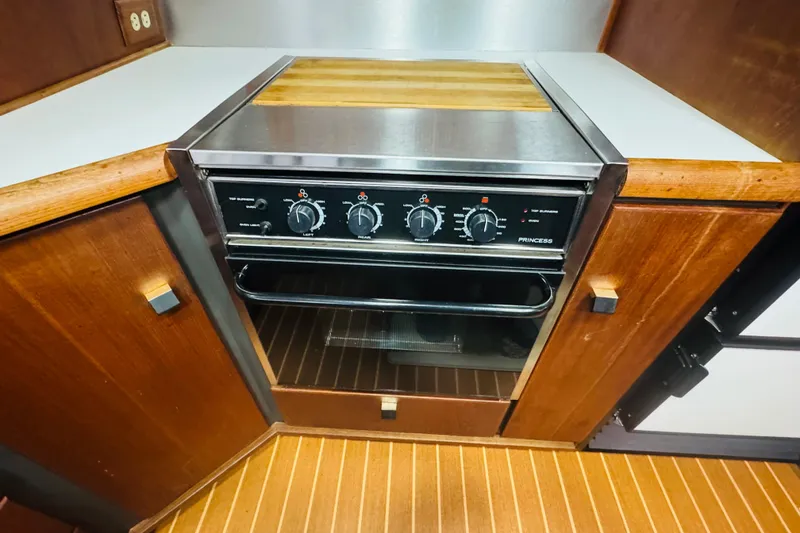 Slide: The Image of 1987 Bayliner 4550 Motoryacht kitchen with a built-in Princess oven and wooden cabinetry. - 49