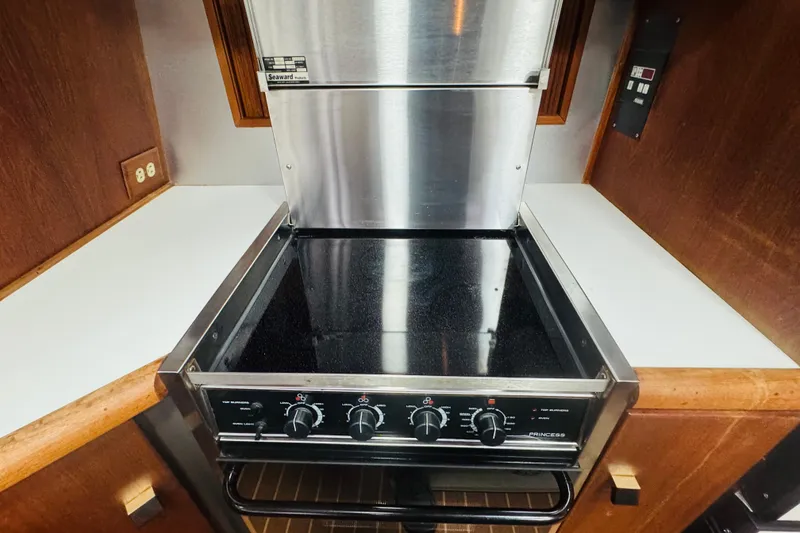 Slide: The Image of Stove in 1987 Bayliner 4550 Motoryacht kitchen, featuring stainless steel and wood accents. - 50