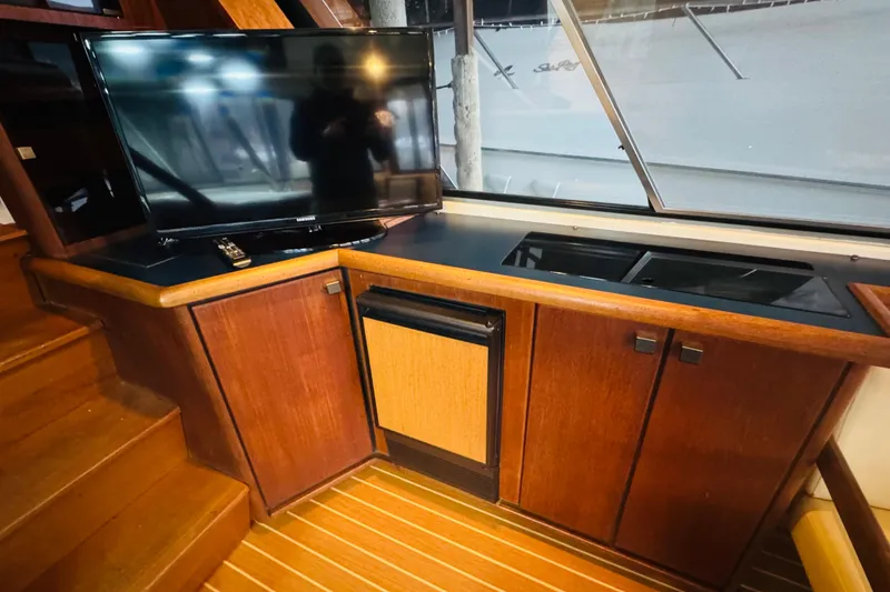 Slide: The Image of 1987 Bayliner 4550 Motoryacht interior with TV, wooden cabinetry, and modern appliances. - 52
